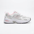 New Balance 530 sneakers in a white colorway with pink accents and silver metallic details